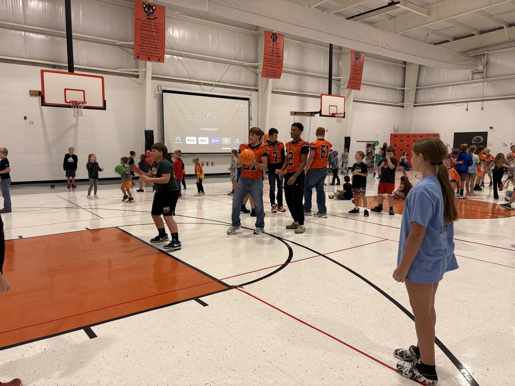 High school athletes playing in gym with students before morning assembly