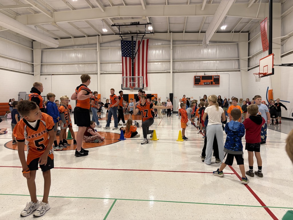 High school athletes playing in gym with students before morning assembly