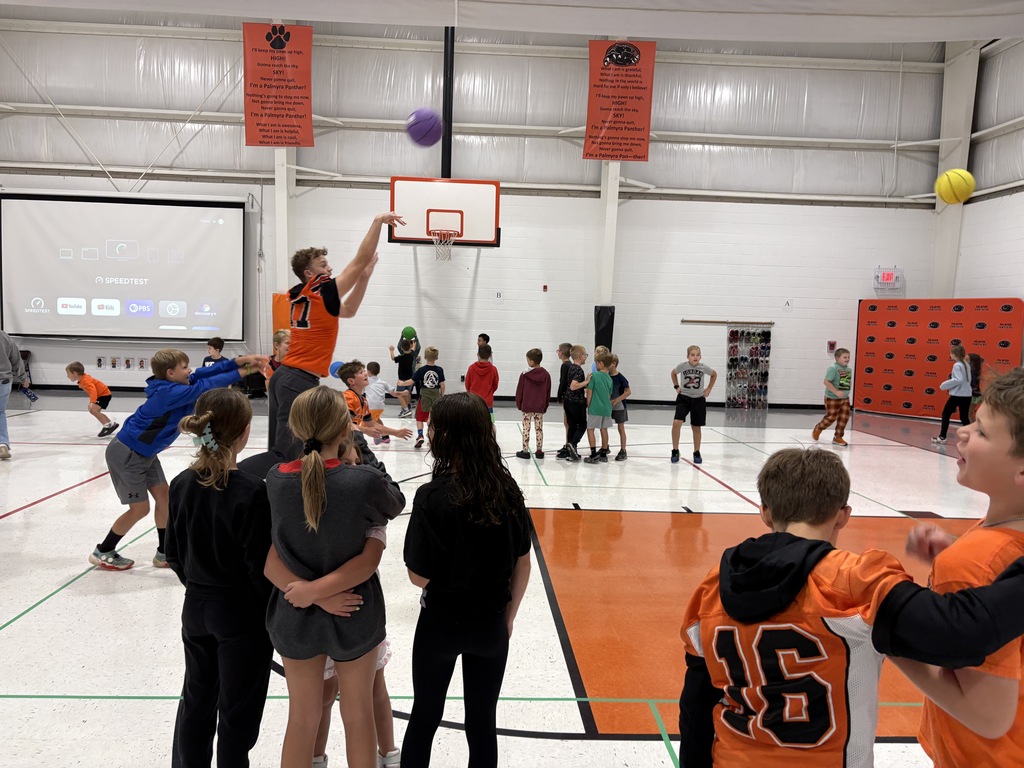 High school athletes playing in gym with students before morning assembly