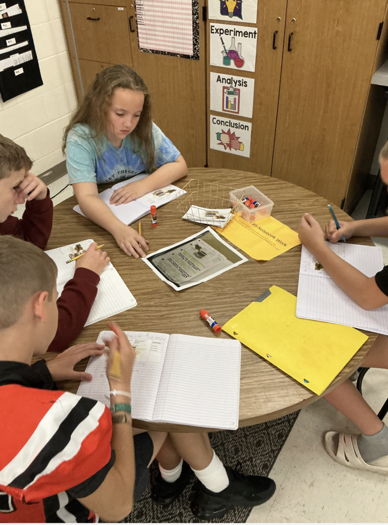 students working on science assignment in classroom