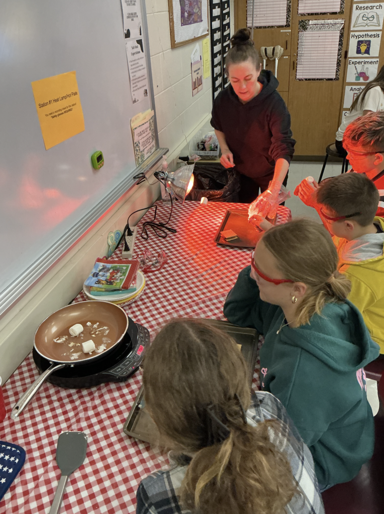 students cooking smores on small cooktop
