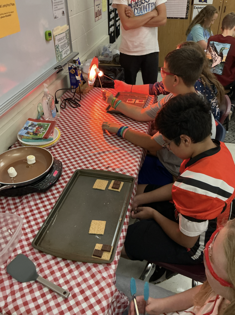 students cooking smores on small cooktop