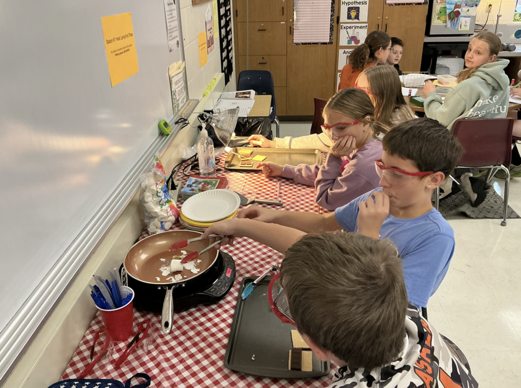 students cooking smores on small cooktop