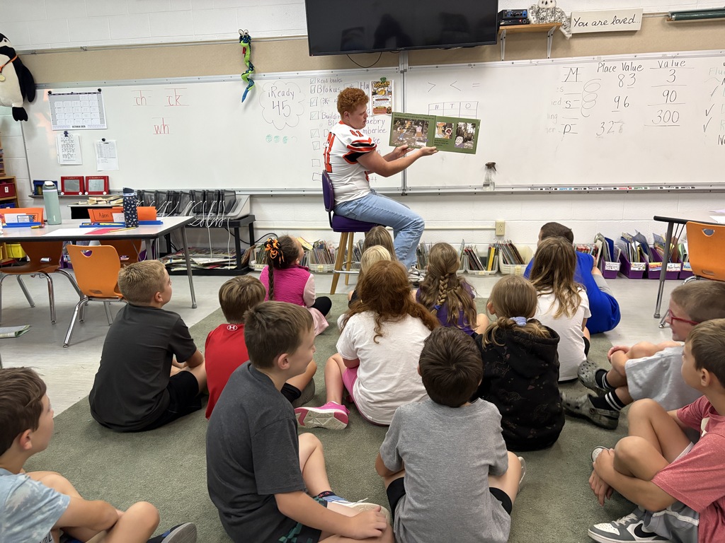 classroom students with 1 football player reading a book