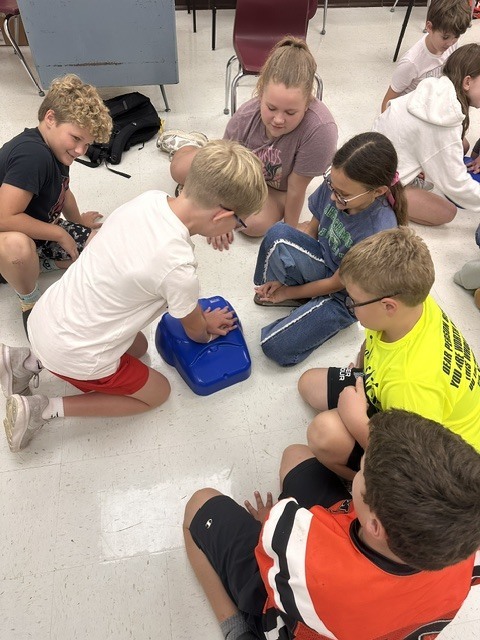 5th grade Health students practicing CPR and the Heimlich maneuver on dummies