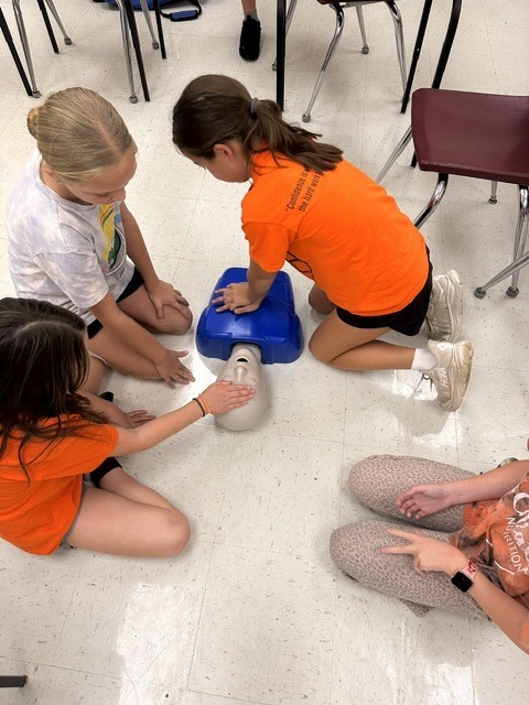 5th grade Health students practicing CPR and the Heimlich maneuver on dummies