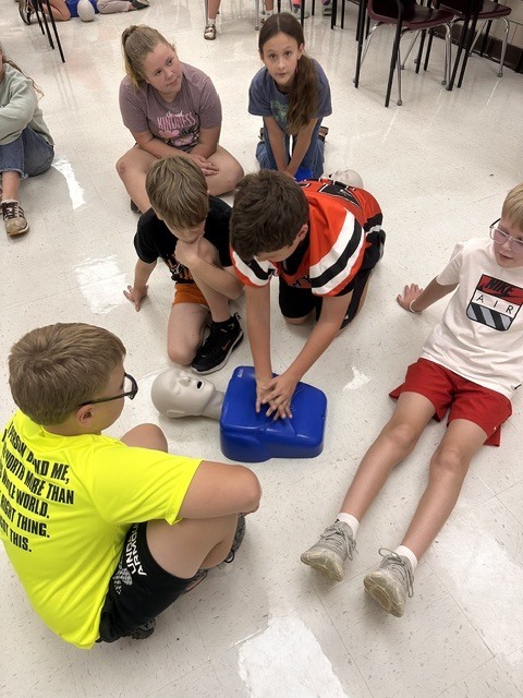 5th grade Health students practicing CPR and the Heimlich maneuver on dummies