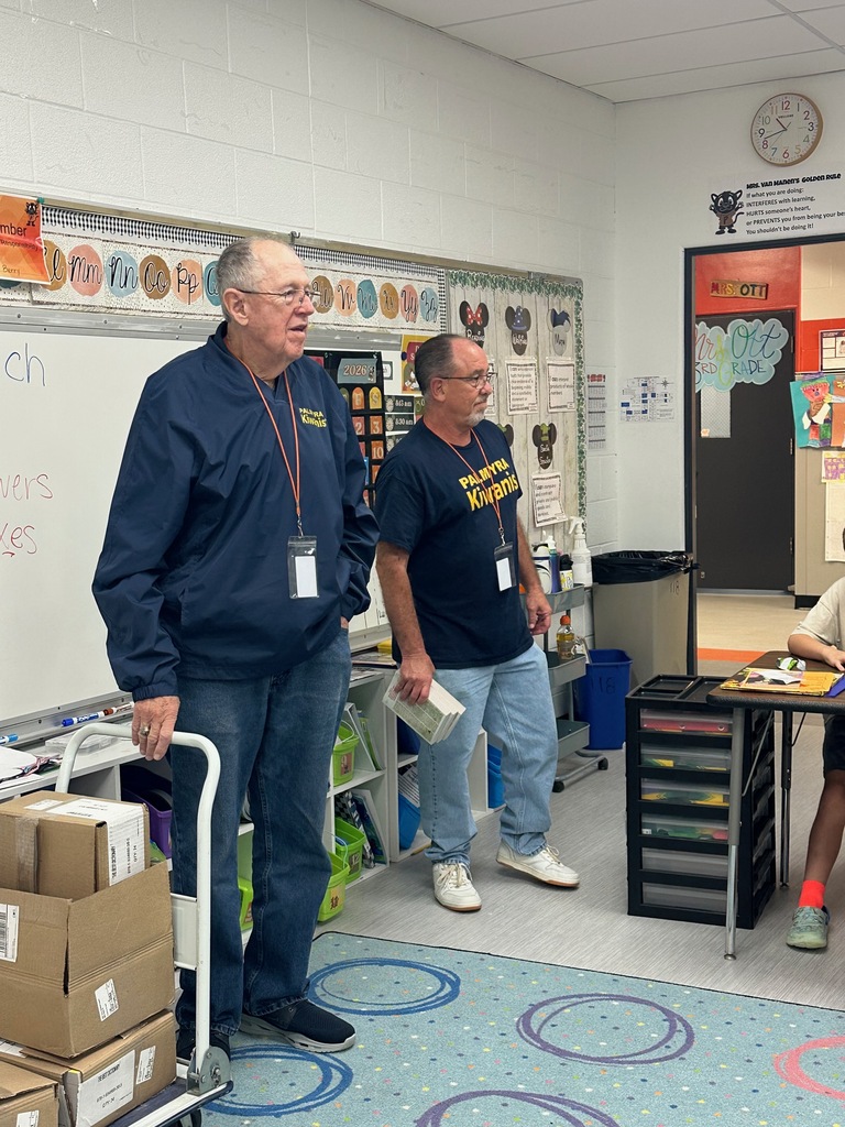 Kiwanis members presenting 3rd grade students with dictionaries