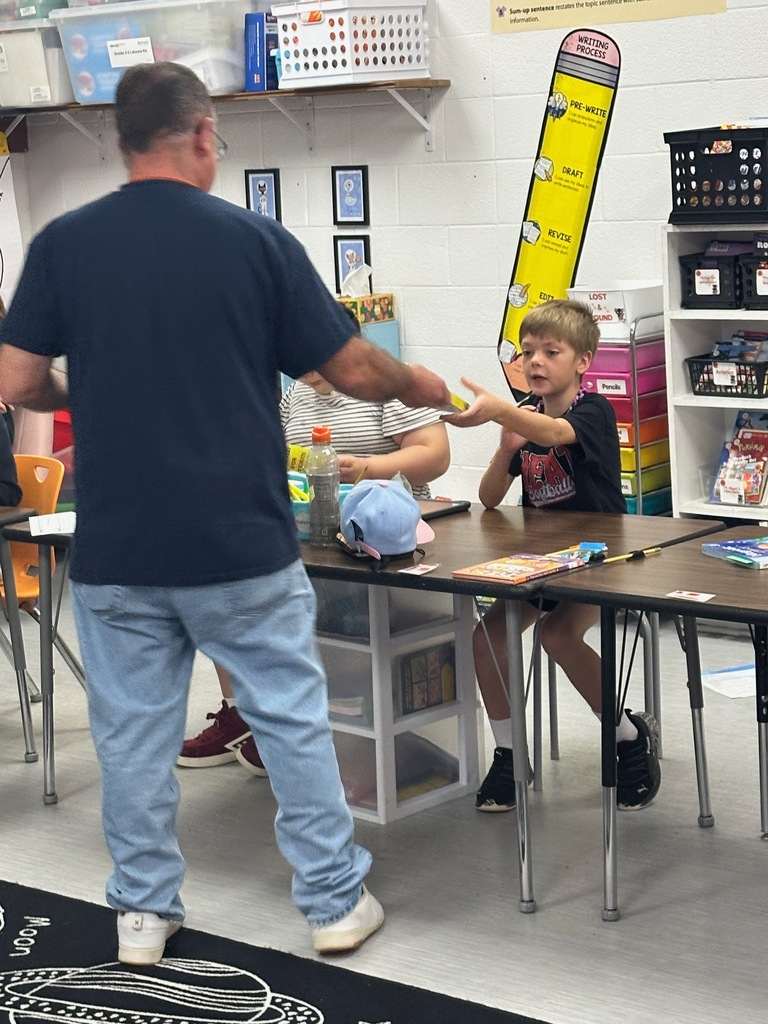 Kiwanis members presenting 3rd grade students with dictionaries