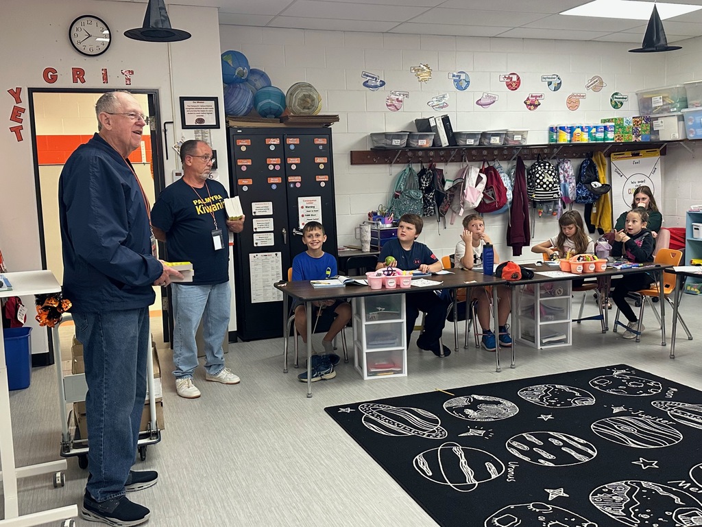 Kiwanis members presenting 3rd grade students with dictionaries