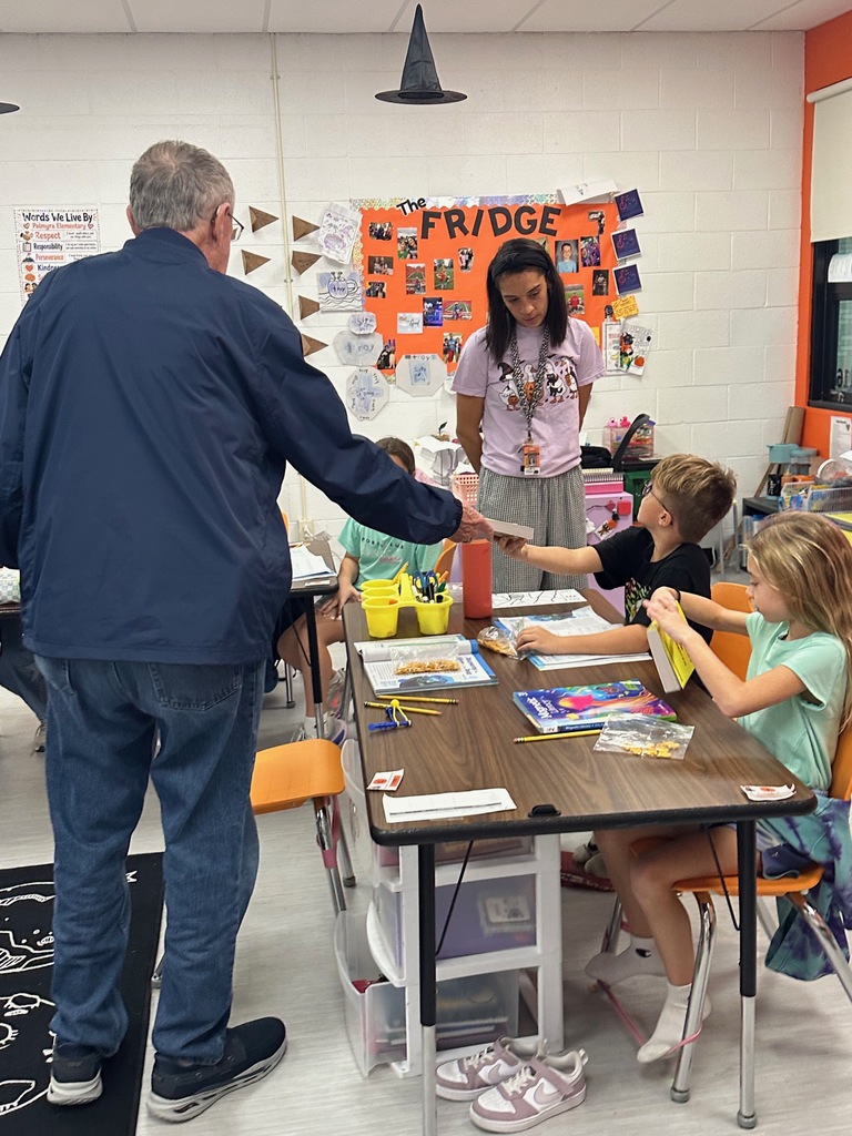 Kiwanis members presenting 3rd grade students with dictionaries