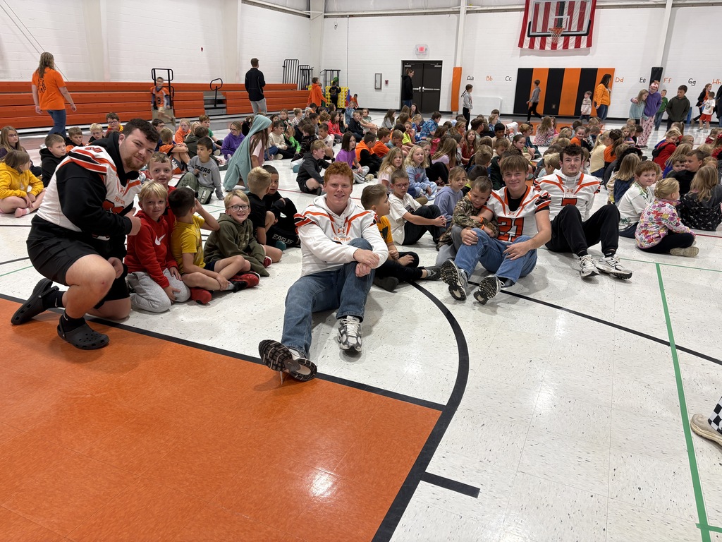 Football players and young Panthers at morning assembly
