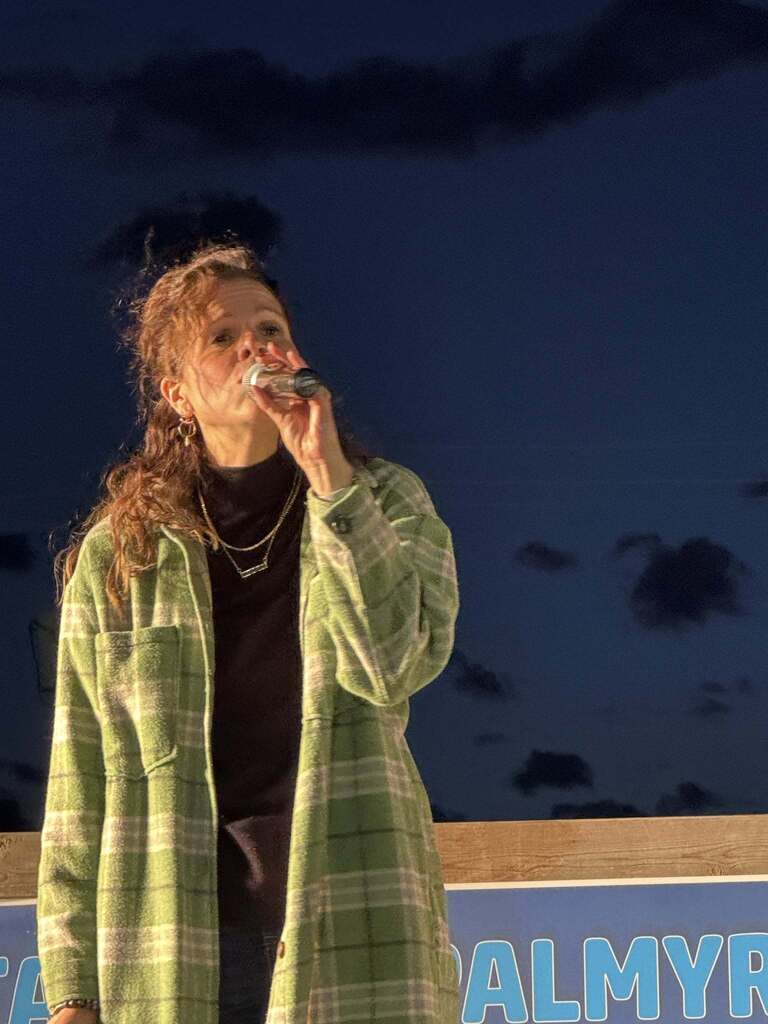 teacher singing on stage at Taste of Palmyra