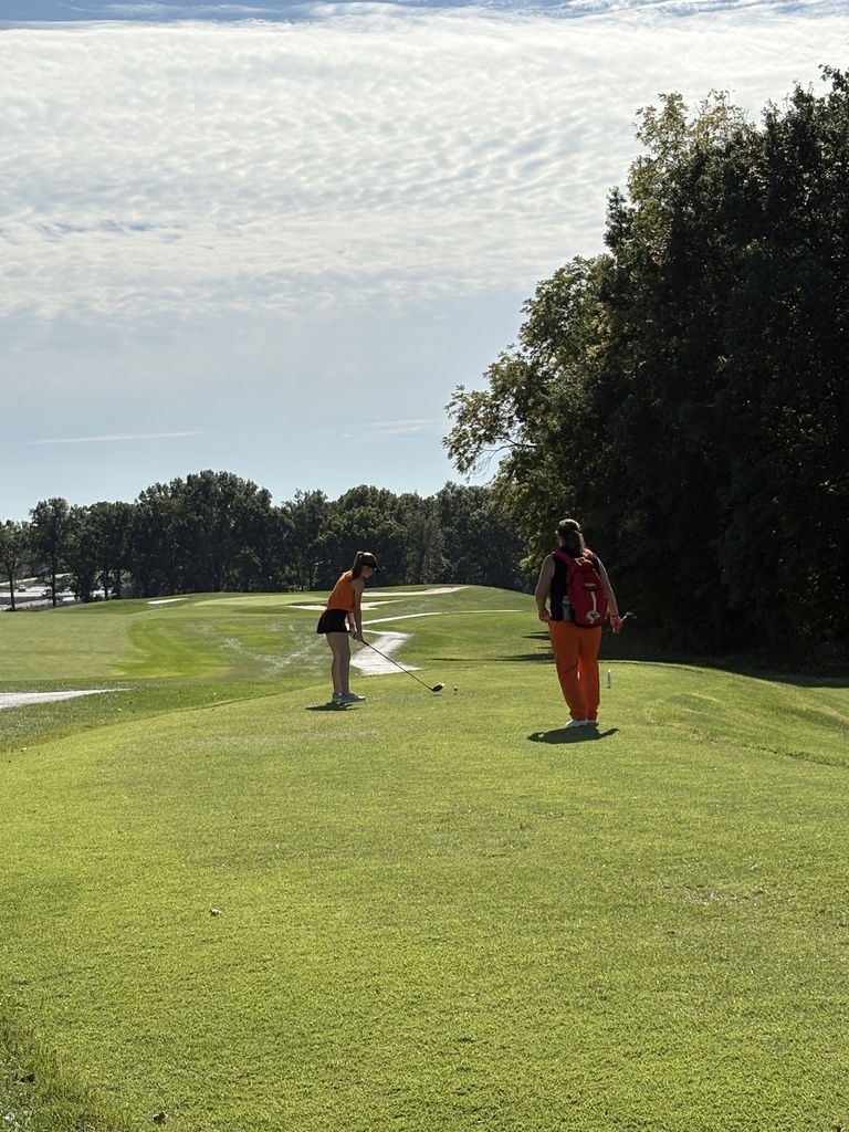 golfer driving ball with coach watching