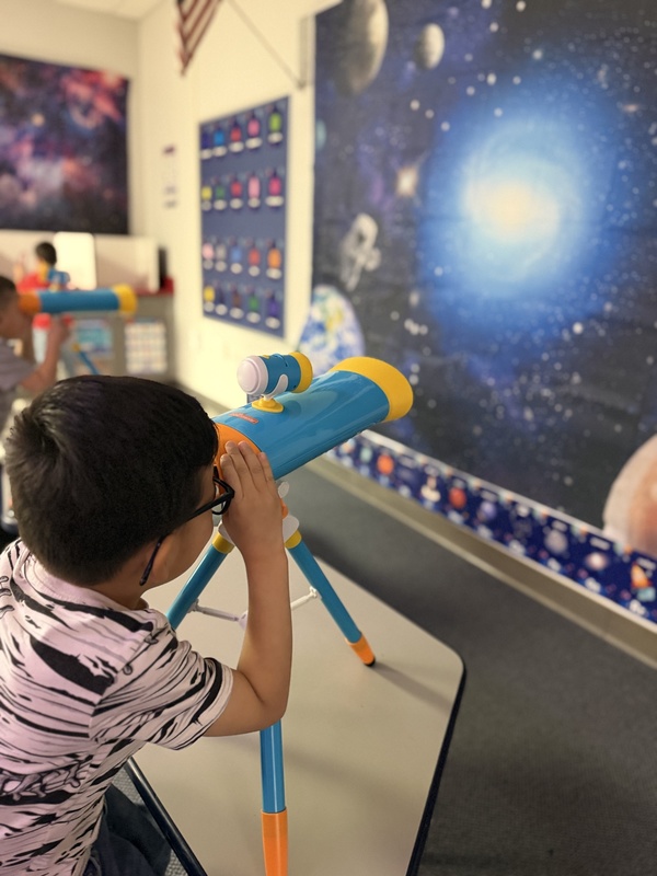 Little boy look through a telescope in Wilson Elementary's new Science Learning Classroom