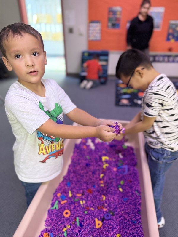Little boy playing in science center at Wilson elementary. Digging for letters.