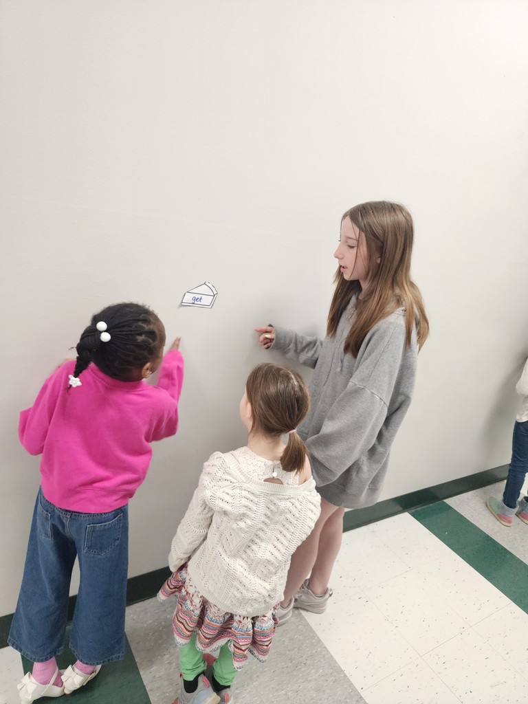 5th Graders and Kindergarteners searching for and reading words. 