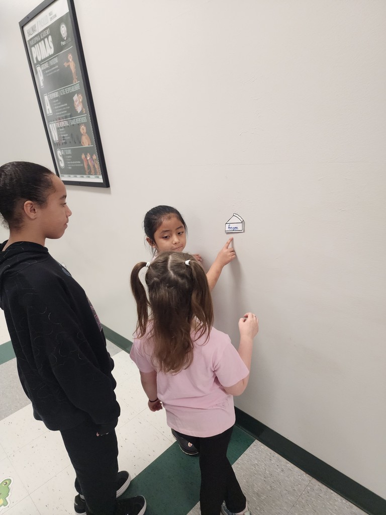 5th Graders and Kindergarteners searching for and reading words. 