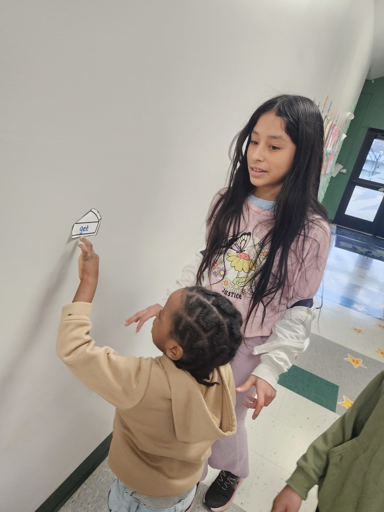 5th Graders and Kindergarteners searching for and reading words. 