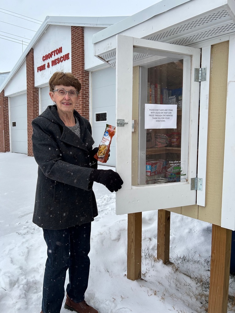 City employee Marlene Hynes checks the food pantry box next to the Crofton City Auditorium