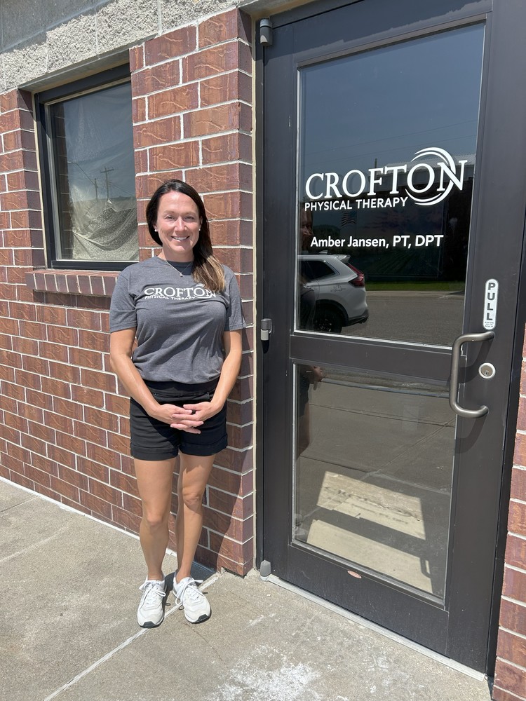 Amber Jansen outside the door to the soon to be open Crofton Physical Therapy in downtown Crofton.