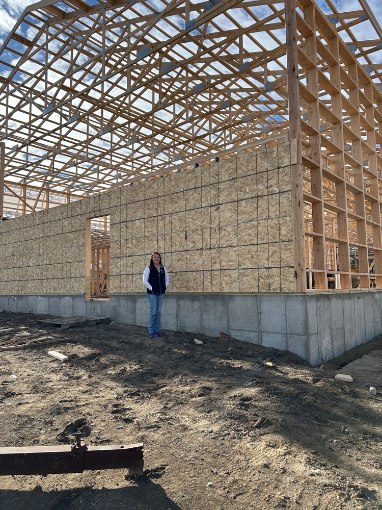 Sarah Petersen in front of the new building taking shape for Flippers Gymnastics