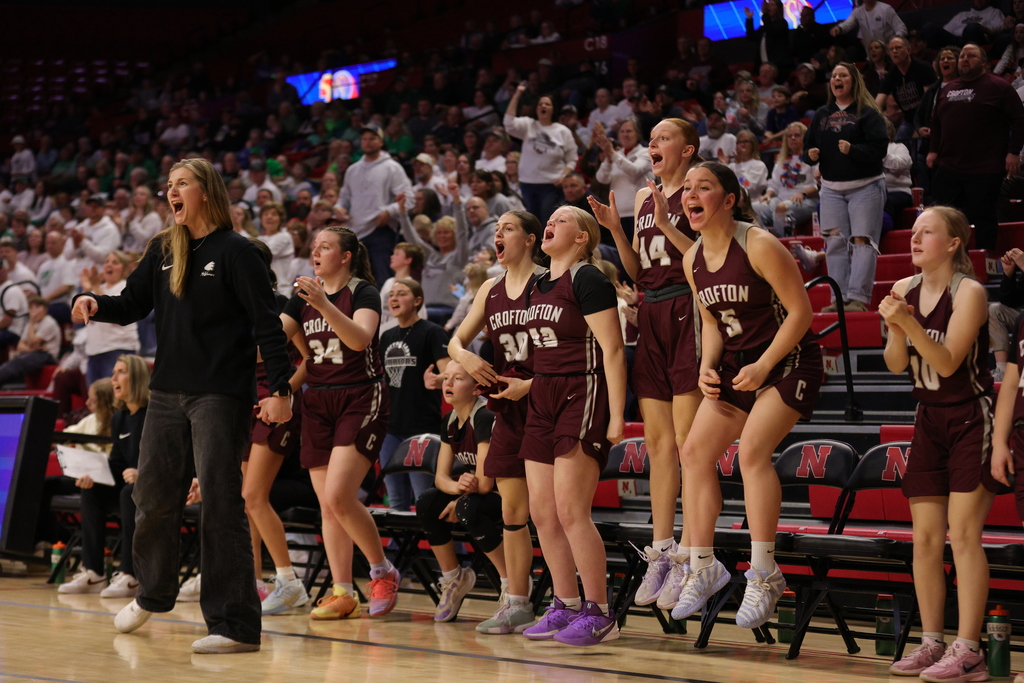 Coach Moon and the Lady Warrior bench celebrating taking the lead ahead of halftime.