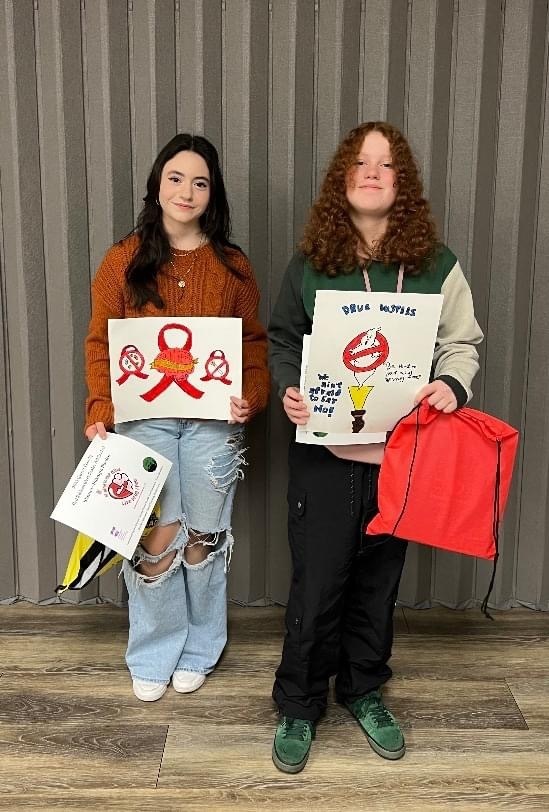 Cambria and Mikayla pose with their Red Ribbon Week artwork