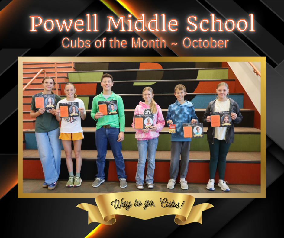 A group of students standing in front of large stairs holding certificates for Cub of the Month.