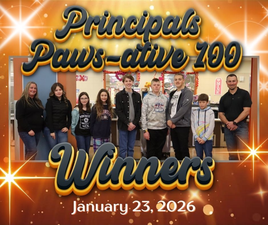 A group of students bookended by two adults standing in front of the cafeteria.