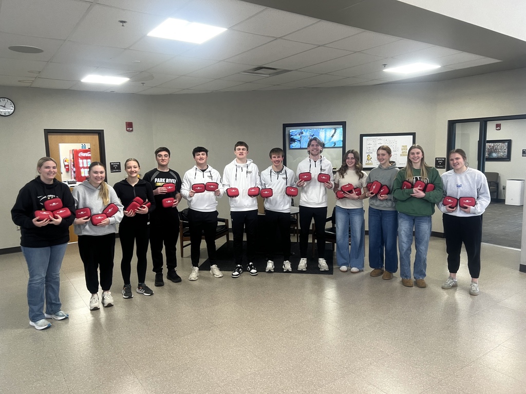NHS students stand with our new first aid kits from First Care Health Center!