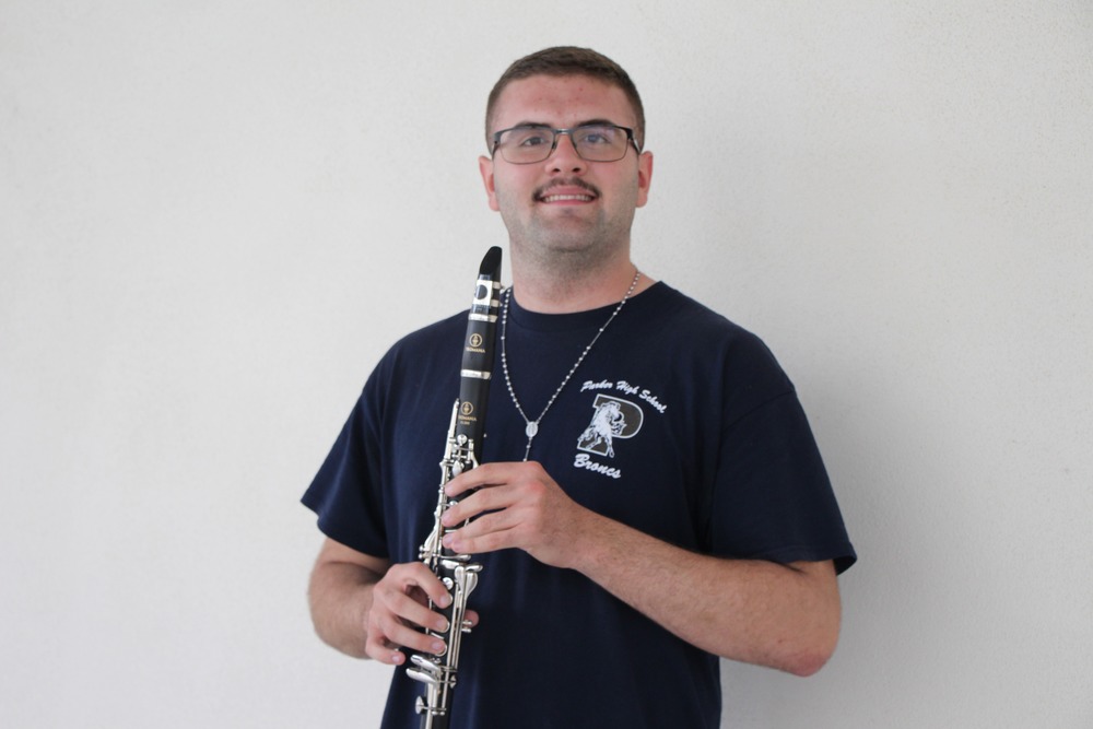Luis is poised in a black PHS shirt holding his clarinet