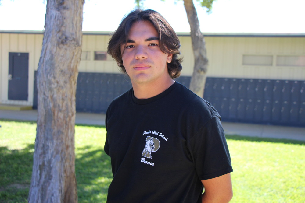 Miguel in school uniform in campus courtyard