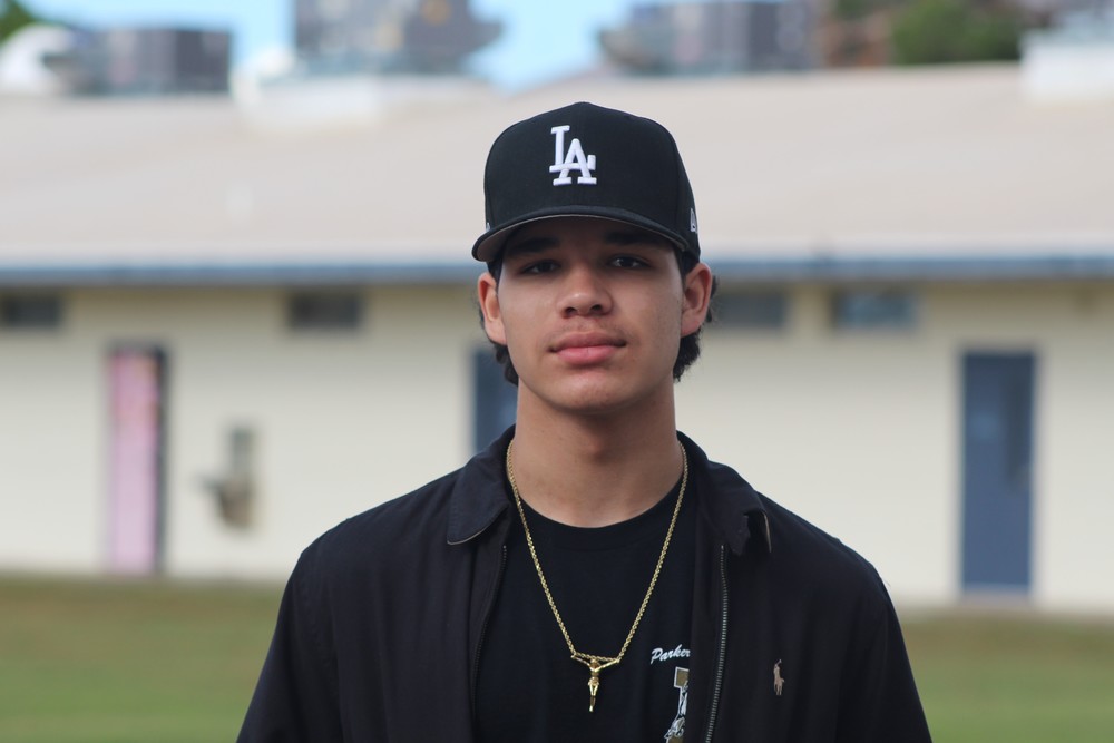 Luke in black with a LA baseball cap and a gold crucifix