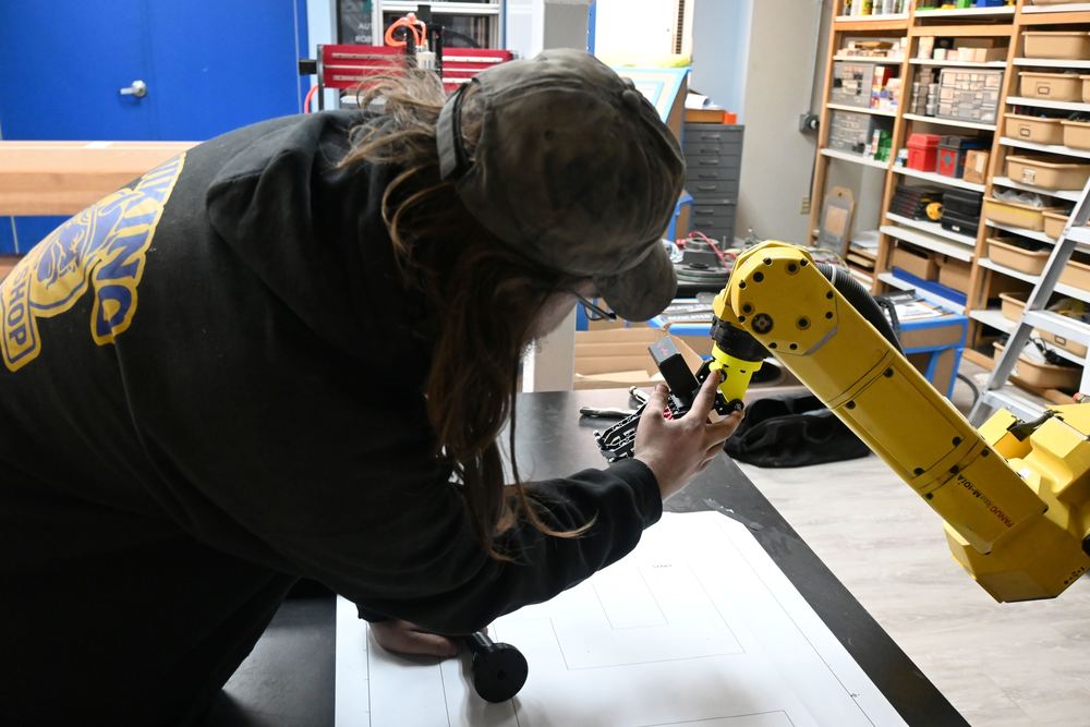 Mason explains the part he created on CAD and 3D printed for the Fanuc robot.