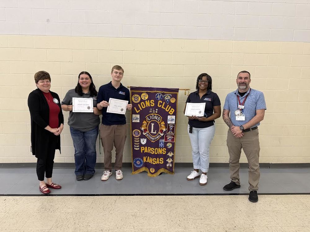 Two Lions Club members pose for a photo with Shayla reliford and two JAG students.