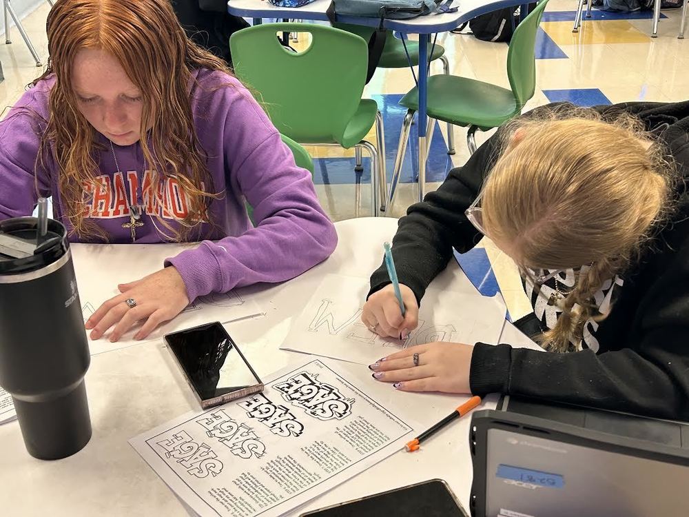 Two girls try to write their names and words as graffiti tags.