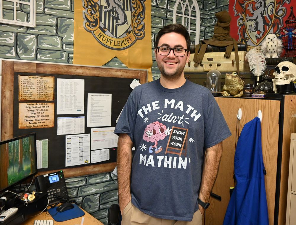 A picture of Cody Holmes, standing by his desk.