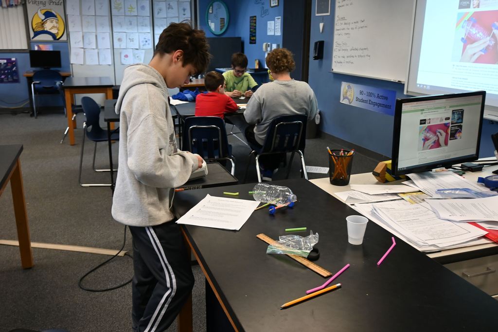 A student attaches his wheels to his rear axel. 