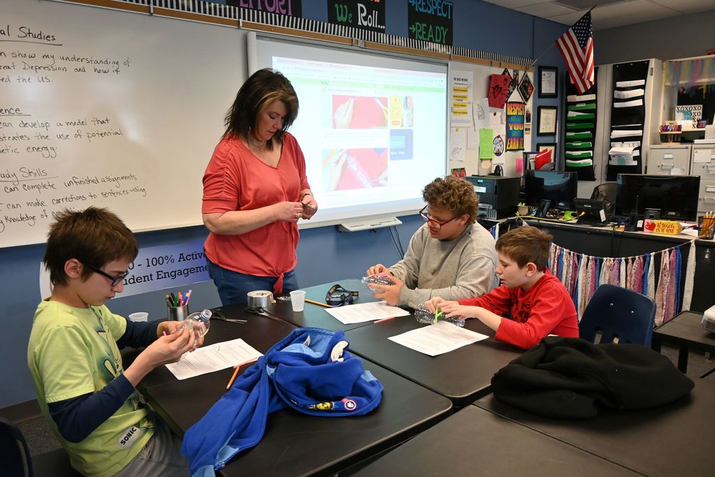 Mrs. Woods cuts duct tape for students to use to afix their axels to their car.