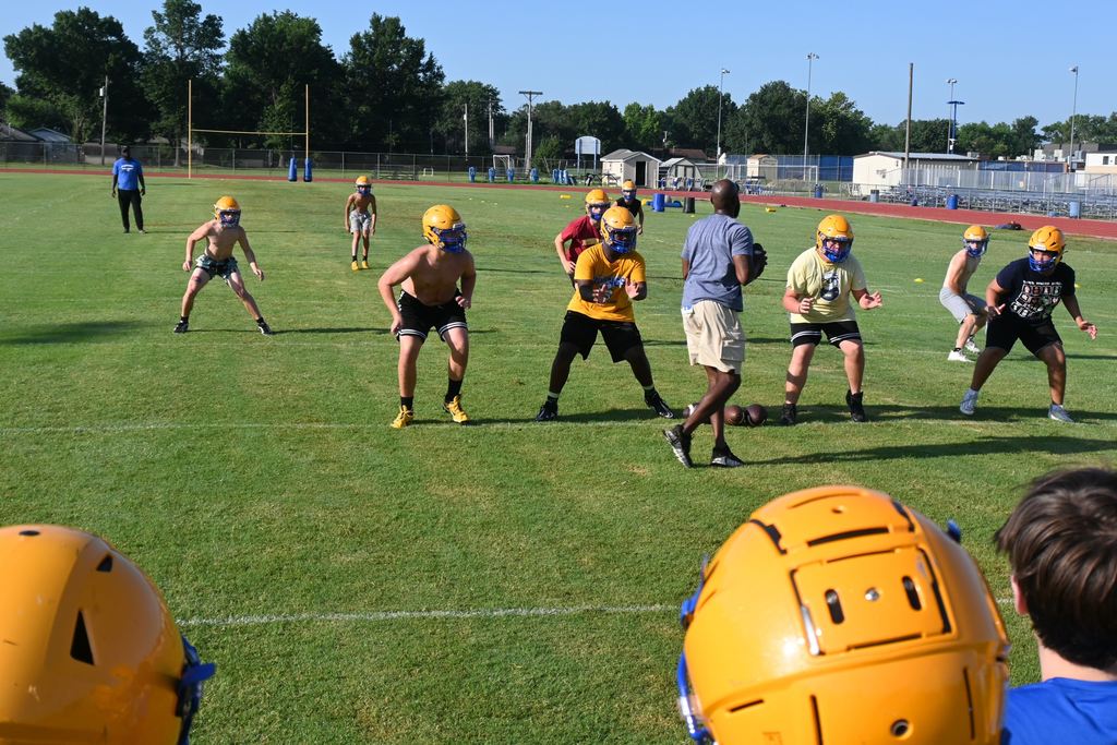 Coach Dumas prepares to throw the football during a drill.