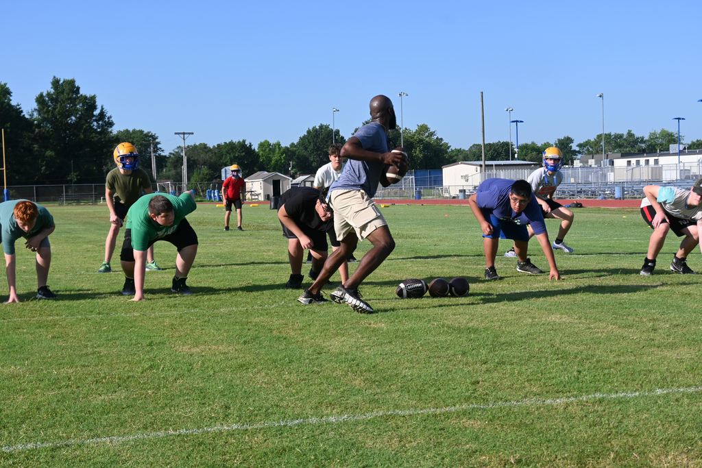 Coach Dumas prepares to throw the football during a drill.