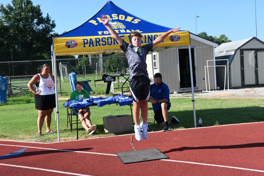 A boy springs up from a mat that will determine his vertical jump height.