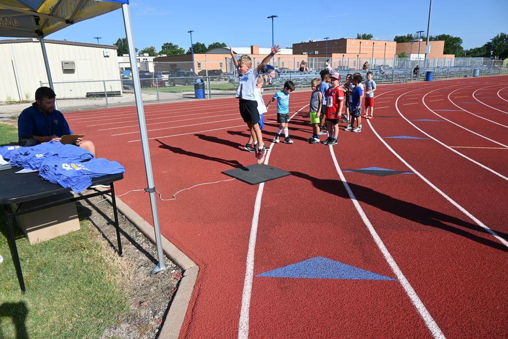 A boy springs up from a mat that will determine his vertical jump height.