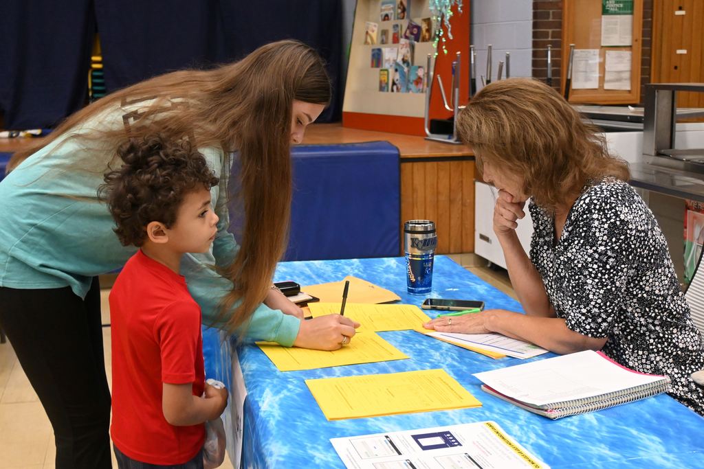 A mother fills out an application for after school,  day care offered  at Lincoln.