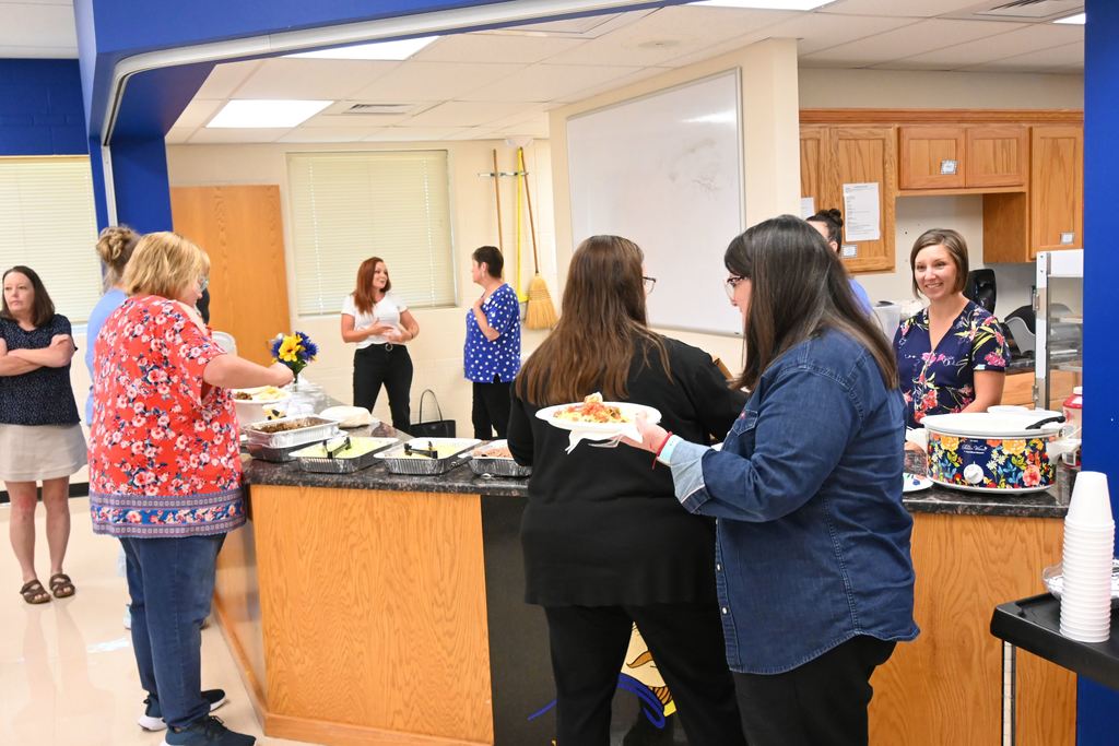 Teachers grab lunch and visit woith district office personnel who were serving them.