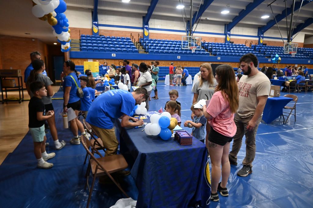 A family stops by the Parsons Middle School table.