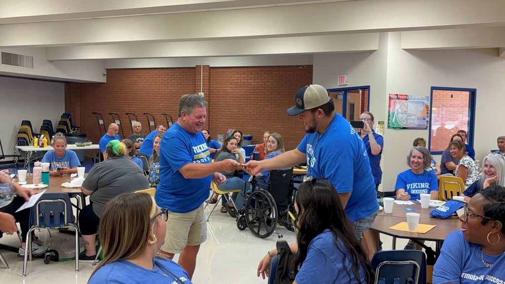 Ray Jacquinot hands a staff member a gift card.
