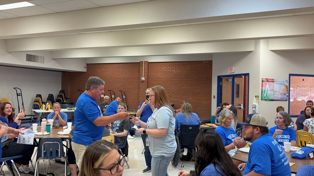 Ray Jacquinot hands a staff member a gift card.