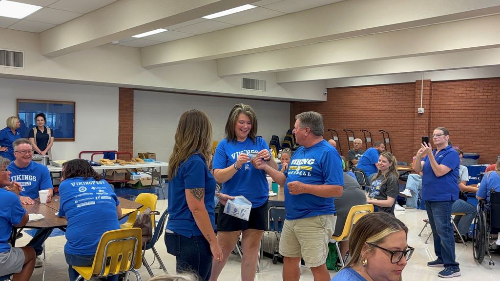 Ray Jacquinot hands a staff member a gift card.